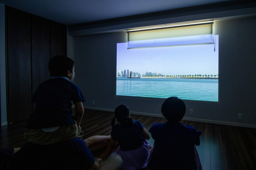 プロジェクターを付けて、映画なども楽しめるようにした主寝室。子供たちも集まってきて、家族みんなで映画を楽しんでいる。