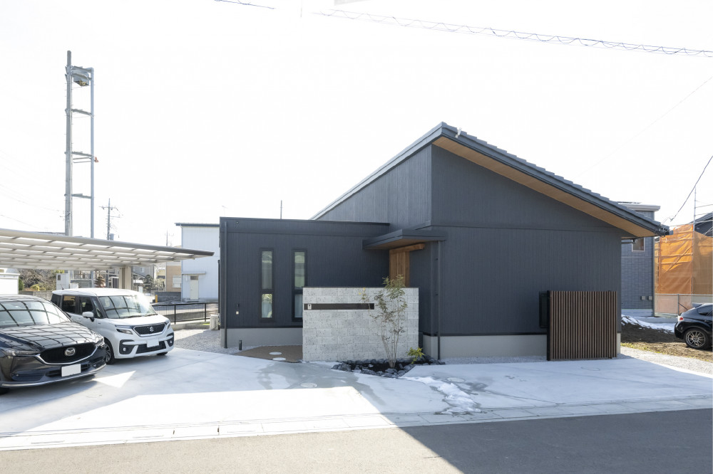 ブラックの外壁とも相性の良い木と大谷石の要素を取り入れ、外観や外構も「和モダン」でトータルコーディネート。片流れの屋根がファサード面のポイントに。太陽光も6kw搭載。