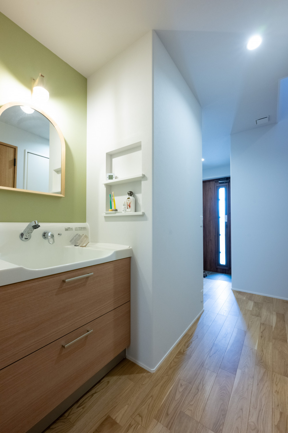 洗面は廊下に設置し、家族がお風呂に入っていても使えます。キッチン、ランドリースペース、洗面が回遊できるので動線がぶつからず使いやすい！洗面台は鏡部分を付替え、造作風に。