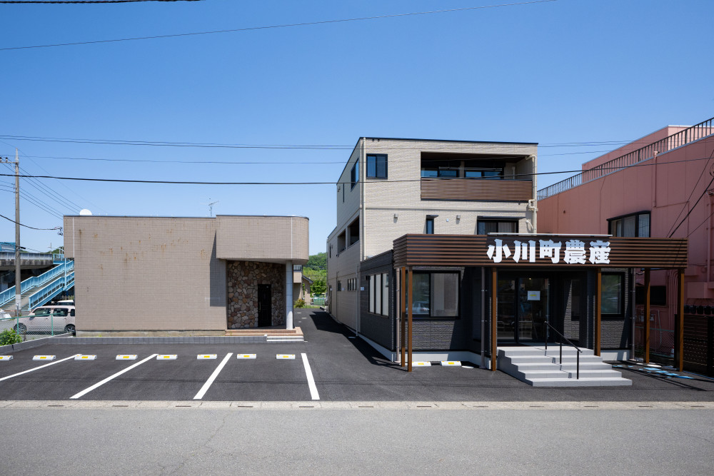 店舗部分は木目調の外観が温かみを演出。駐車場と、入口には手すり付きのステップを設けてお客様を迎えます。 購入した土地に建っていた隣の空き店舗も、ゆくゆくは使って店舗を拡大していけたらと、今後の展望も。