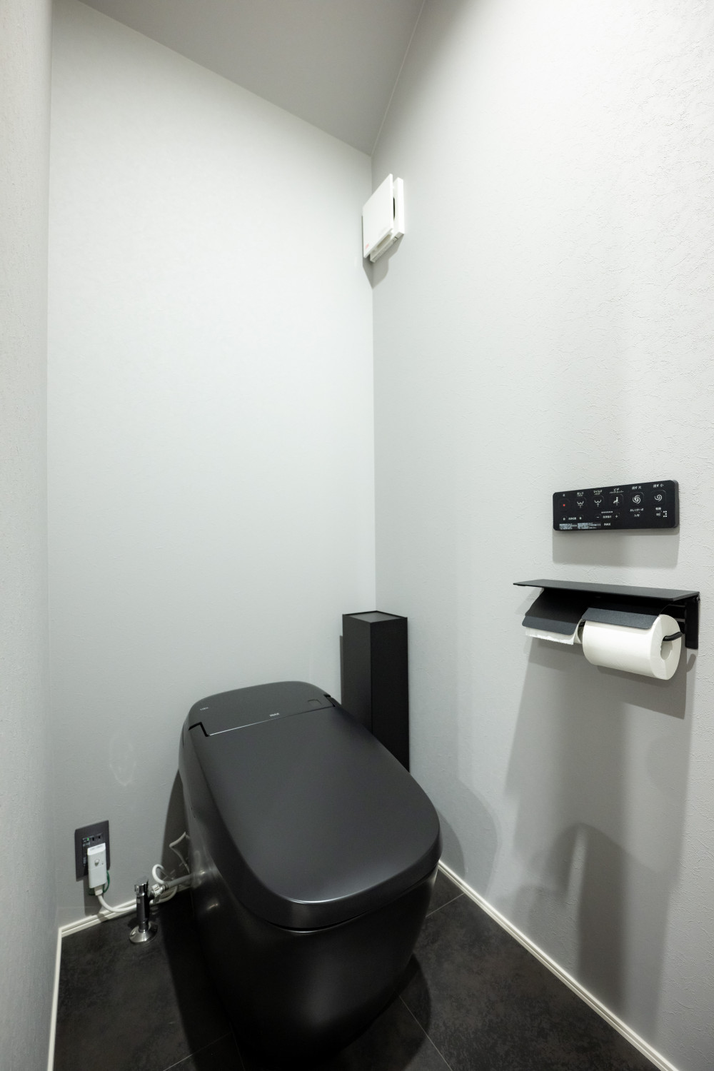 ブラックのタンクレストイレとグレーの壁紙で、店舗のようなスタイリッシュさを演出。
