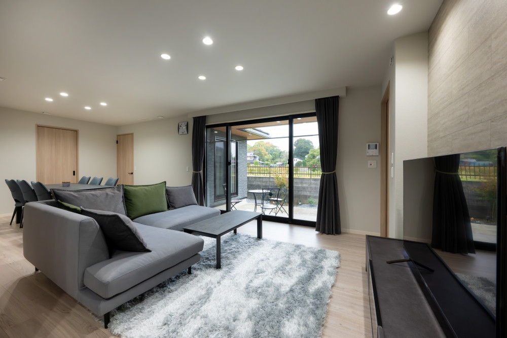 中庭を中心に広がる、くつろぎと開放感のLDK。L字ソファと6人掛けのダイニングテーブルを配置し、人が集まってもゆったり過ごせるレイアウトに。