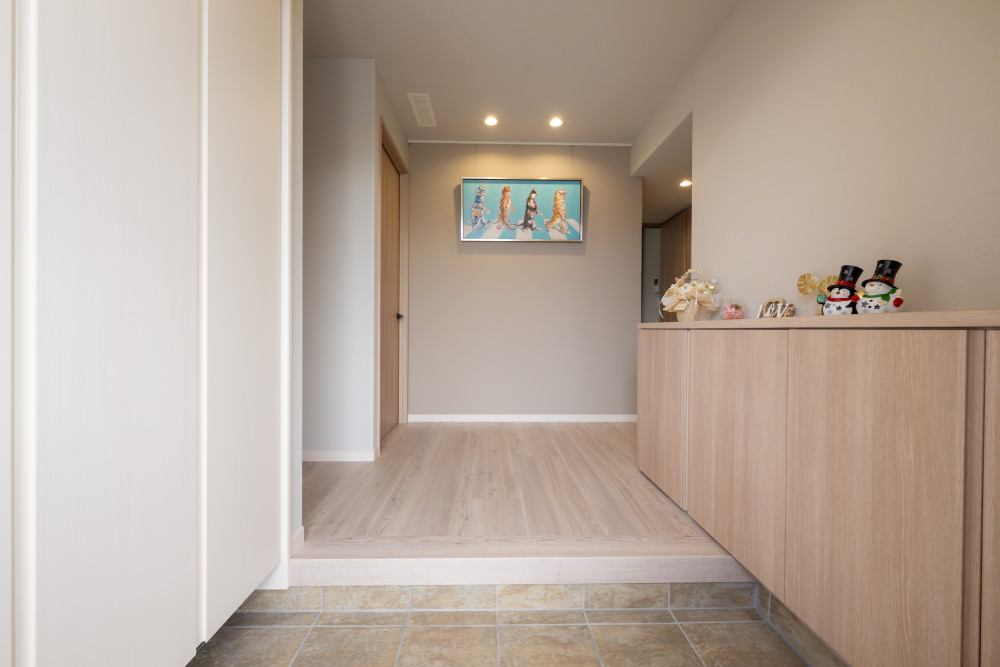 ネコ好きのT様らしいオイルペイントのアートがアイキャッチの玄関。玄関クローゼットに収納量を確保することで、すっきりと奥行きある印象の玄関に。